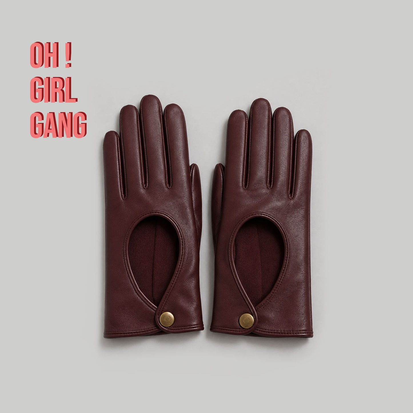 Pair of genuine leather driving gloves in burgundy, white, black, featuring an elegant open-back teardrop cutout with snap-button closure. Soft premium leather with a classic vintage-inspired design, displayed on a light grey background.