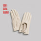 Pair of genuine leather driving gloves in burgundy, white, black, featuring an elegant open-back teardrop cutout with snap-button closure. Soft premium leather with a classic vintage-inspired design, displayed on a light grey background.