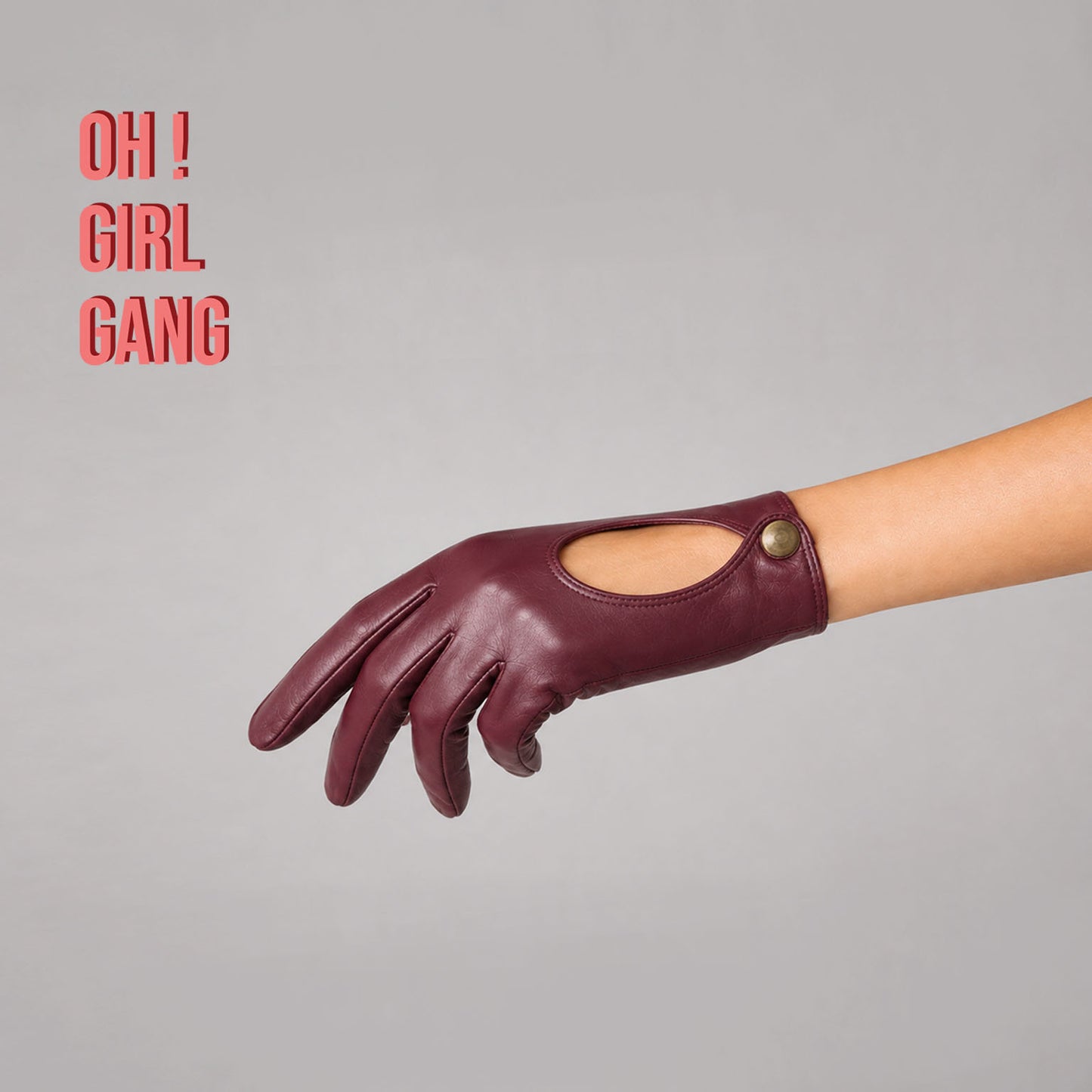 Pair of genuine leather driving gloves in burgundy, white, black, featuring an elegant open-back teardrop cutout with snap-button closure. Soft premium leather with a classic vintage-inspired design, displayed on a light grey background.