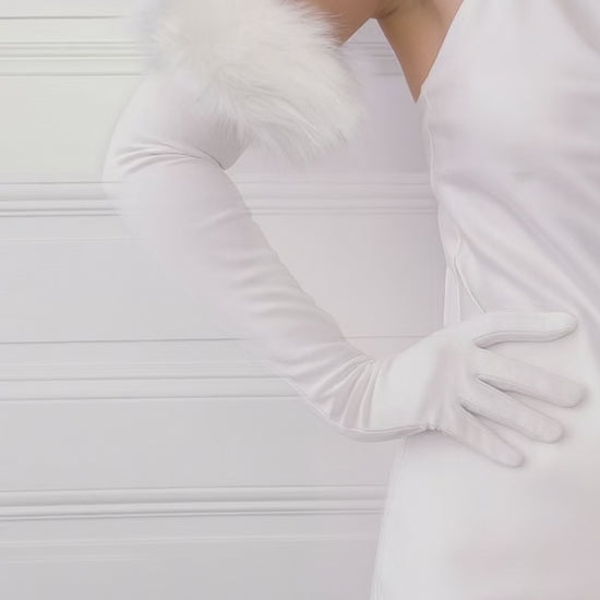Step back in time with our White Flurry Suede Opera Gloves. Measuring 65cm, these exquisite gloves are crafted from soft suede and adorned with luxurious faux fur, making them the perfect accessory for any elegant occasion.